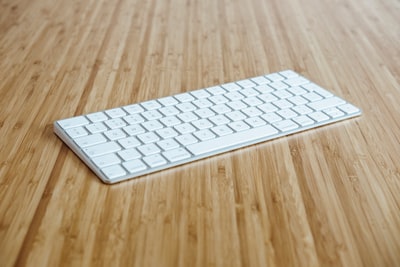 棕色木质表面的银白色键盘